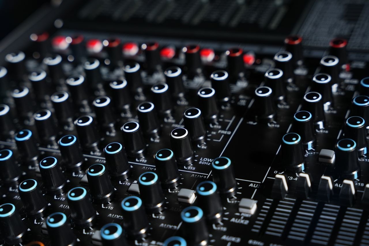 Detailed view of a professional audio mixing console with various dials and faders.